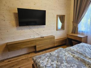 a bedroom with a flat screen television on a wall at Chata Paja in Liptovský Mikuláš
