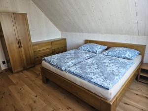 ein Schlafzimmer mit einem Bett mit blauer Decke in der Unterkunft Chata Paja in Liptovský Mikuláš
