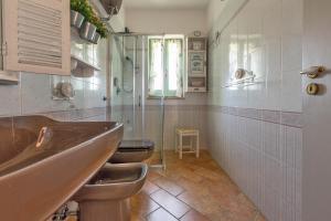 een badkamer met 2 toiletten, een wastafel en een douche bij Fabula Maison in Monopoli