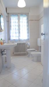 uma casa de banho com um lavatório, um WC e uma janela. em Guest House Malaguzzi em Reggio Emilia