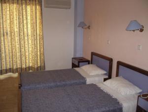 a hotel room with two beds and a window at Rhodian Sun Hotel in Paradeísion
