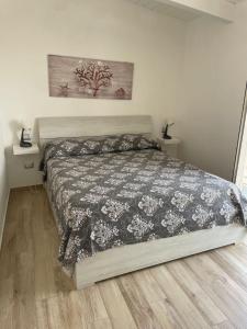 a bedroom with a bed with a black and white comforter at Casa di nonno sta in Santa Maria di Castellabate