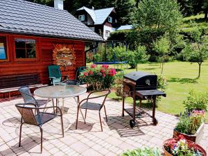 a patio with a grill and a table and chairs at Apartmány Petronela in Makov