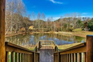 eine Holzbrücke über einen See mit einem Zaun in der Unterkunft Spectacular MTNS Views with PRIVATE HOT TUB with Pool Table and Private Pond in Sevierville