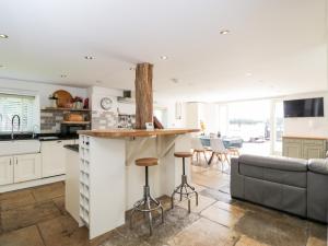 a kitchen and living room with a bar and a couch at 2 Dewars Farm Cottages in Bicester