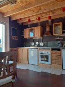a large kitchen with white appliances and wooden cabinets at Charmante maison atypique in Régusse
