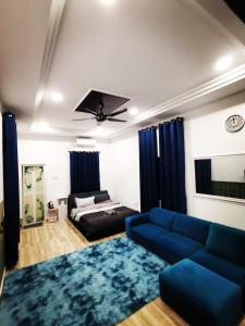 a living room with a blue couch and a bed at MINI HOTEL CONCEPT in Kuala Terengganu