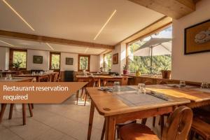 a restaurant with wooden tables and chairs and a window at Hotel & Restaurant Perret - Mountain People in Valgrisenche