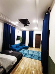 salon z łóżkiem i niebieską kanapą w obiekcie MINI HOTEL CONCEPT w mieście Kuala Terengganu