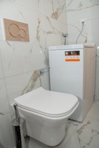 La salle de bains est pourvue de toilettes blanches et de murs en marbre. dans l'établissement Valery's Artistic Home, à Athènes