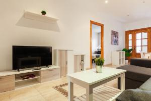 uma sala de estar com uma televisão de ecrã plano e uma mesa em Ciudad Jardín A3 Lanjarón 13 em Almeria