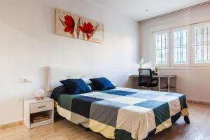 um quarto com uma cama com um cobertor azul e branco em Ciudad Jardín A3 Lanjarón 13 em Almeria