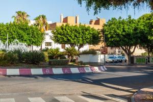 uma rua com um passeio com carros estacionados na estrada em Ciudad Jardín A3 Lanjarón 13 em Almeria