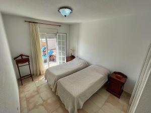 um quarto com 2 camas, uma mesa e uma janela em Villa Isabel em Adeje