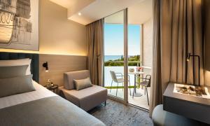 a hotel room with a bed and a balcony at Aminess Vival Maestral Hotel in Novigrad Istria