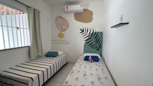 a room with two beds and a window at Casinha de Sapê in Santo Amaro