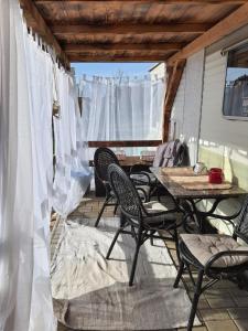 un patio con mesa y sillas en un porche en Mobilheim v LVA 1, en Podivín