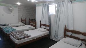 a room with three beds and a window at Hotel Estação Norte - Fácil acesso ao Imbel e o distrito industrial e colégio Militar - By Up Hotel in Juiz de Fora