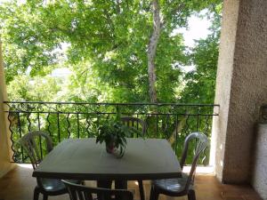 a table with a potted plant on a balcony at Sur les hauteurs du Luberon in Cucuron