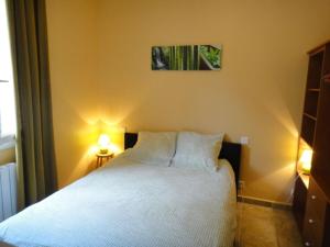 a bedroom with a white bed with two pillows at Sur les hauteurs du Luberon in Cucuron