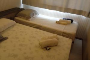 two beds in a hotel room with towels on them at TOP DA PRAIA - 2qts, ar cond, WIFI, cozinha, garagem , completo in Vila Velha