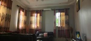sala de estar con cortinas, sofá y ventana en Vero house, en Zanzíbar