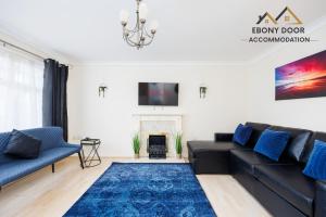 a living room with a black couch and a blue rug at Ebony Door Accommodation Charming 3 Bedroom House Thurrock Sleeps 6 in Grays Thurrock