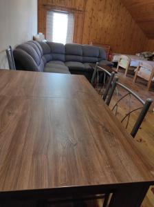 a large wooden table in a living room with a couch at Stadnina koni Tarka in Zwierzyniec +92 photos