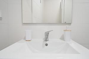 a white bathroom with a sink and a mirror at Right Place in Lisbon