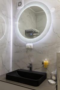 bagno con lavandino nero e specchio di Rayyan Apartment a Zagabria