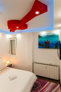 a bedroom with a bed and a red ceiling at Rayyan Apartment in Zagreb