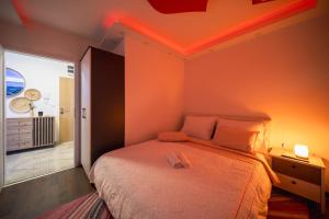 a bedroom with a bed with orange lights on the ceiling at Rayyan Apartment in Zagreb