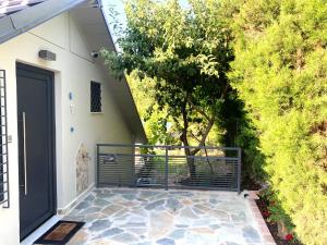 a house with a black door and a tree at Coastal vista retreat in Neos Panteleimonas