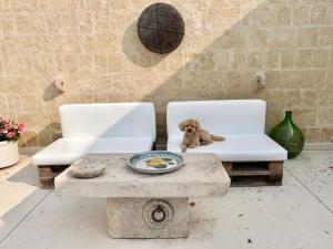 ein ausgestopfter Teddybär, der in zwei weißen Stühlen sitzt in der Unterkunft Masseria Spiga in Gravina in Puglia