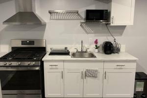 a kitchen with a sink and a stove top oven at *Cozy, newly renovated, fully equipped* in Hamilton