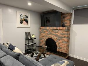 uma sala de estar com um sofá e uma lareira de tijolos em *Cozy, newly renovated, fully equipped* em Hamilton