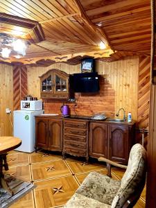 a kitchen with wooden cabinets and a refrigerator and a tv at У Болгарина in Mykulychyn