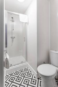 a white bathroom with a shower and a toilet at City Centre Studio 8 with Kitchenette, Free Wifi and Smart TV with Netflix by Yoko Property in Middlesbrough