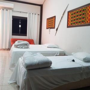 a room with two beds and a window at Pousada dos Bosques - Refúgio Urbano in Cuiabá