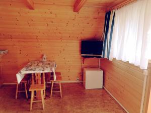 a dining room with a table and chairs in a cabin at DOLINA NAD MOŁSTOWĄ in Starnin