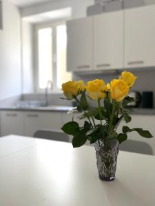un vaso di rose gialle seduto su un tavolo in cucina di Koper Relax home a Capodistria