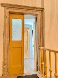 una porta gialla in un corridoio con scala di Koper Relax home a Capodistria
