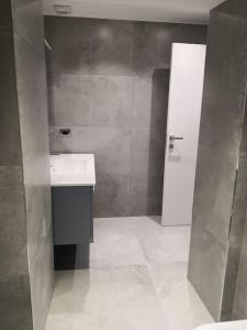 La salle de bains est pourvue d'un lavabo blanc et d'une douche. dans l'établissement Casa Annabella, à Roddi
