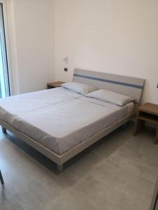 een bed in een witte kamer met bij Casa Annabella in Roddi
