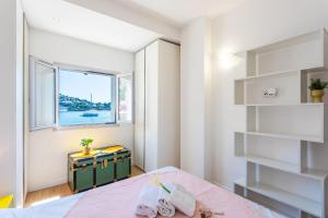 a bedroom with a bed and a window at LA RESERVE AP4369 By Riviera Holiday Homes in Villefranche-sur-Mer