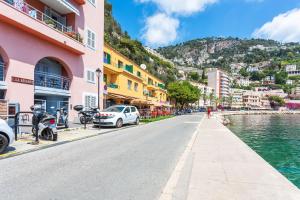 a street in a town next to a body of water at LA RESERVE AP4369 By Riviera Holiday Homes in Villefranche-sur-Mer