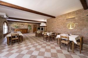 ein Restaurant mit Tischen und Stühlen und einer Backsteinmauer in der Unterkunft La Tenuta Va Oltre in Bovolenta