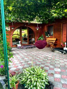 a patio with plants and a building with a bench at У Болгарина in Mykulychyn