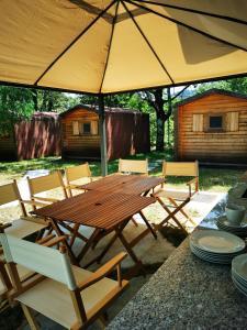un tavolo in legno e sedie sotto un ombrellone di Krasen Kras 104 resort a Komen