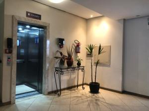 a hallway with a door with plants on it at Hotel Graju Itajaí in Itajaí